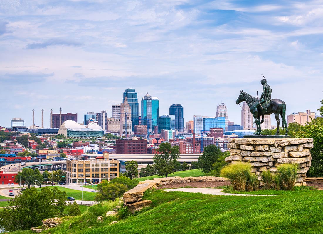 Insurance Solutions - Kansas City Skyline View of a Sunny Day with Statue in the Foreground